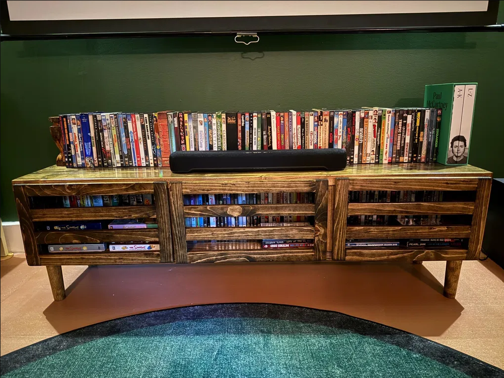 Dark wood TV stand with modern door panels, open shelves, and two drawers
