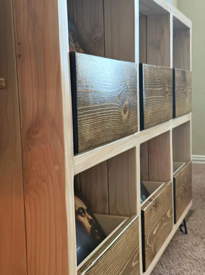 Wood and white vinyl record storage cabinet corner with drawer doors and open shelves