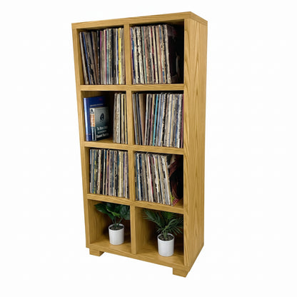 Light wood vinyl record storage cabinet with open cubbies and stacked records