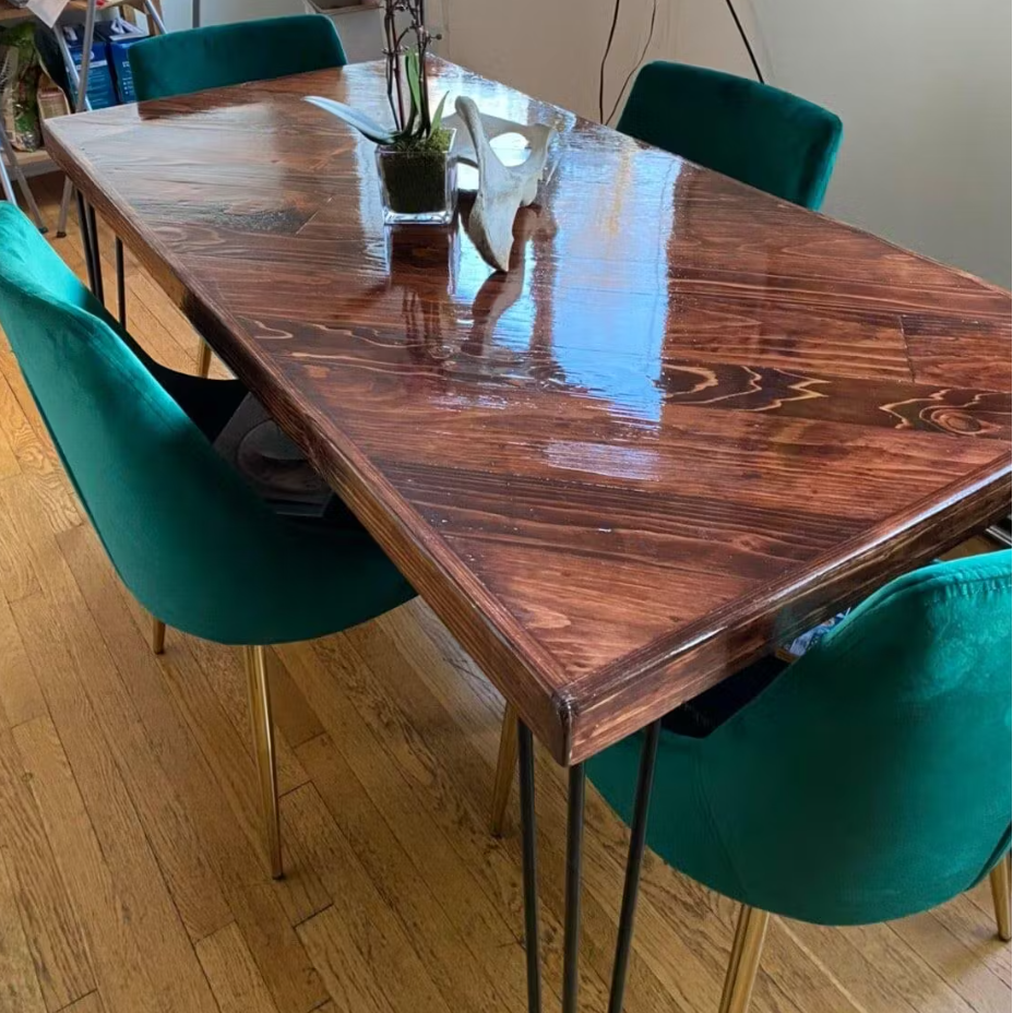 Wooden dining table with teal chairs on a wooden floor