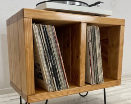 Wooden record storage rack with open front compartments and slanted magazine holders