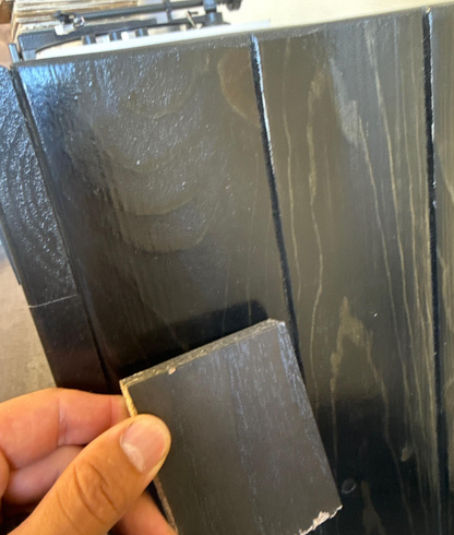 Dark gray/black rigid board sample with textured finish and squared edge